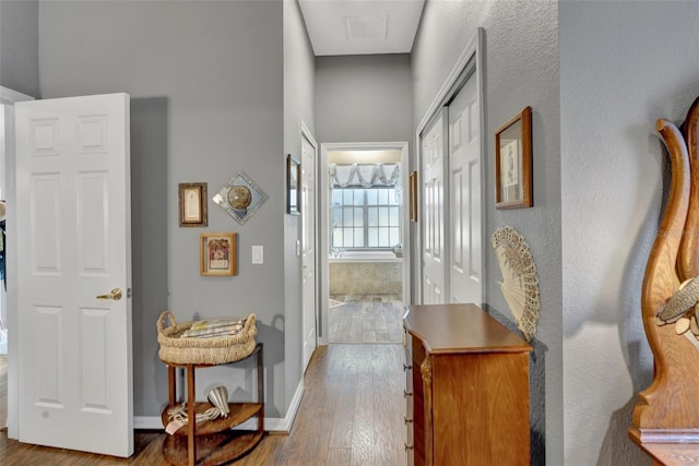 2533 Wood Pointe Dr, Holiday, FL 34691 - hallway featuring hardwood / wood-style flooring, baseboards, and a towering ceiling