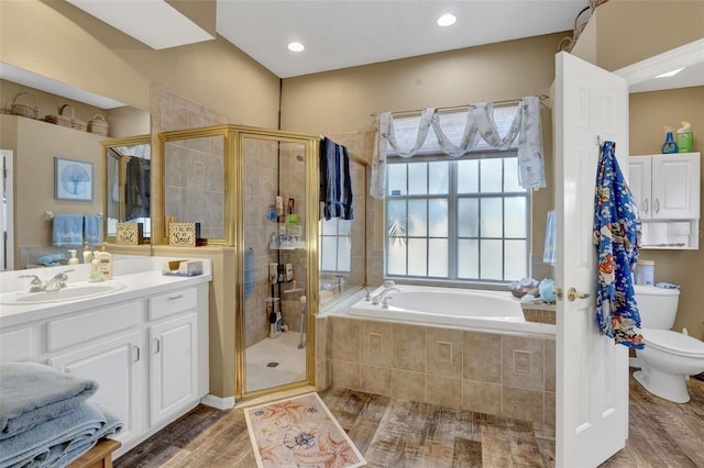 full bathroom with hardwood / wood-style floors, vanity, toilet, and separate shower and tub