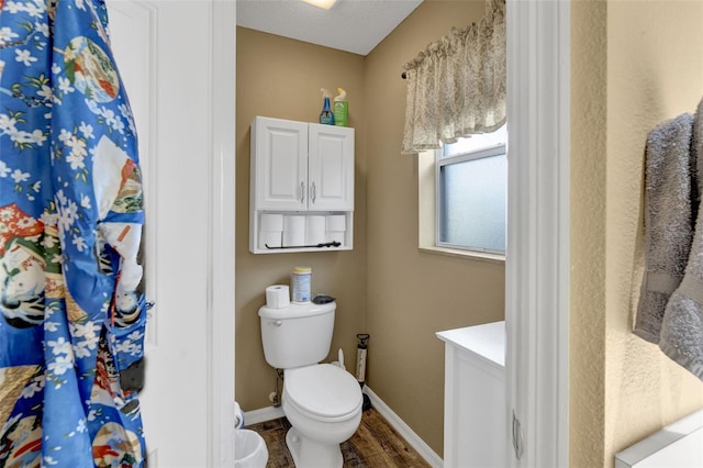 bathroom featuring a textured ceiling, vanity, hardwood / wood-style flooring, and toilet