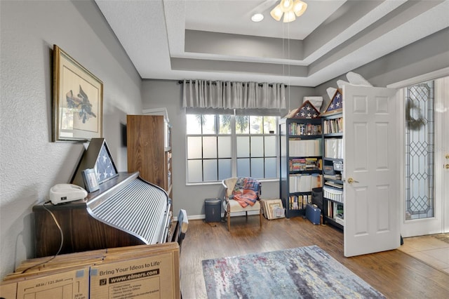2533 Wood Pointe Dr, Holiday, FL 34691 - bedroom featuring wood finished floors, a raised ceiling, and baseboards