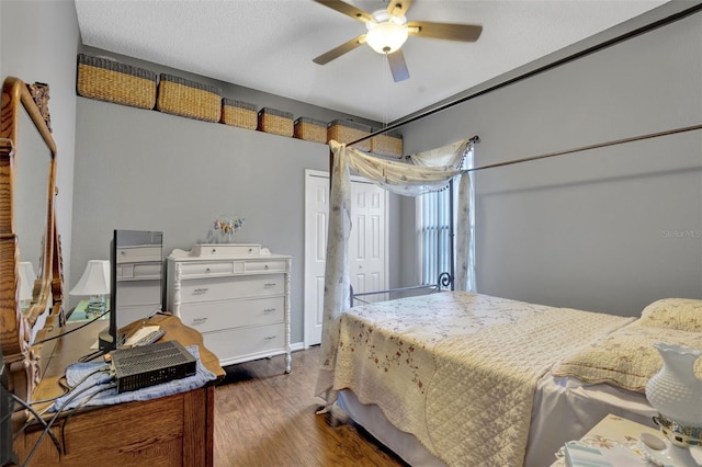 bedroom featuring wood-type flooring, ceiling fan, and a textured ceiling