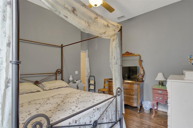 bedroom with dark wood-type flooring, ceiling fan, and a textured ceiling