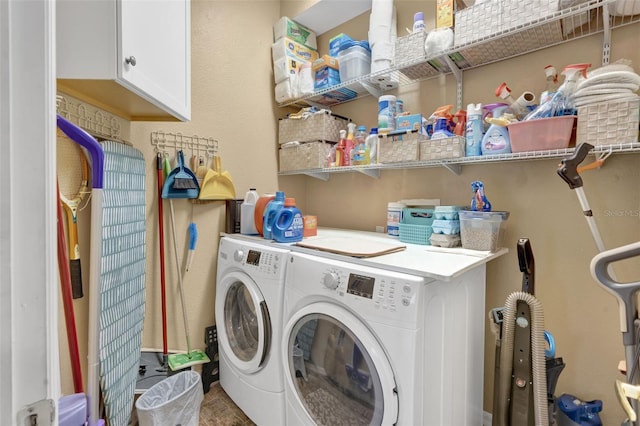 clothes washing area with cabinets and separate washer and dryer