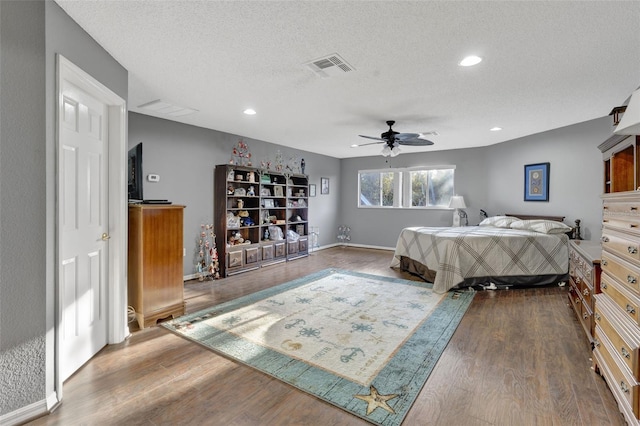 bedroom featuring wood-type flooring, ceiling fan, and a textured ceiling