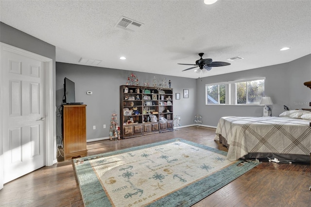 bedroom featuring ceiling fan, dark hardwood / wood-style floors, and a textured ceiling