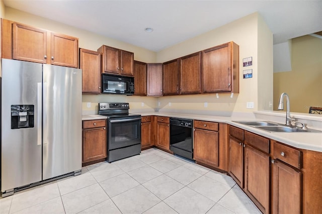 kitchen with light tile patterned flooring, sink, and black appliances