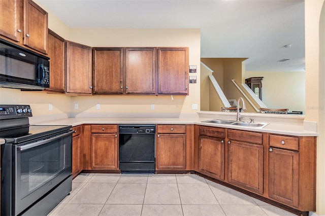 kitchen featuring black appliances, sink, and light tile patterned floors