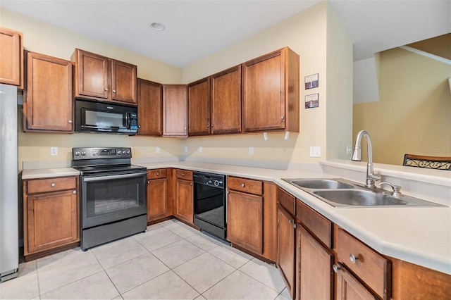 kitchen featuring black appliances, sink, and light tile patterned floors