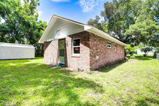 view of side of property featuring an outbuilding and a yard