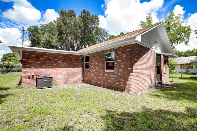 exterior space featuring central AC unit and a lawn