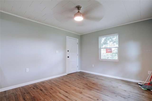 empty room featuring ceiling fan, light wood-type flooring, and crown molding