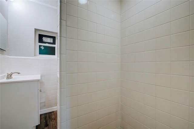 bathroom with tile walls, hardwood / wood-style floors, and vanity