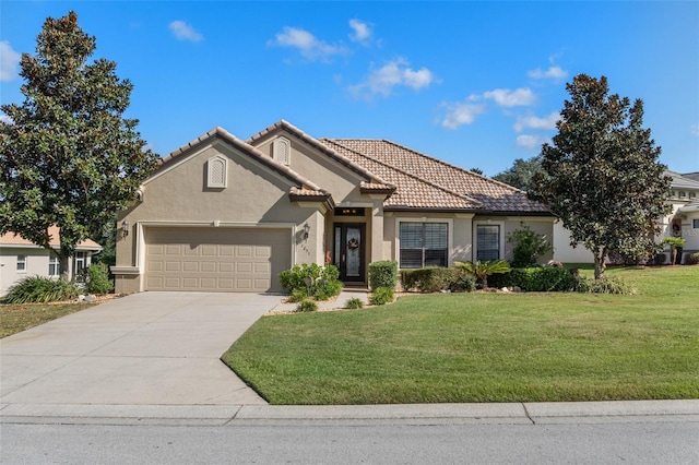 mediterranean / spanish house featuring a garage and a front yard