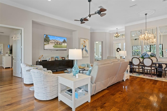 living room with hardwood / wood-style floors, ceiling fan with notable chandelier, and crown molding