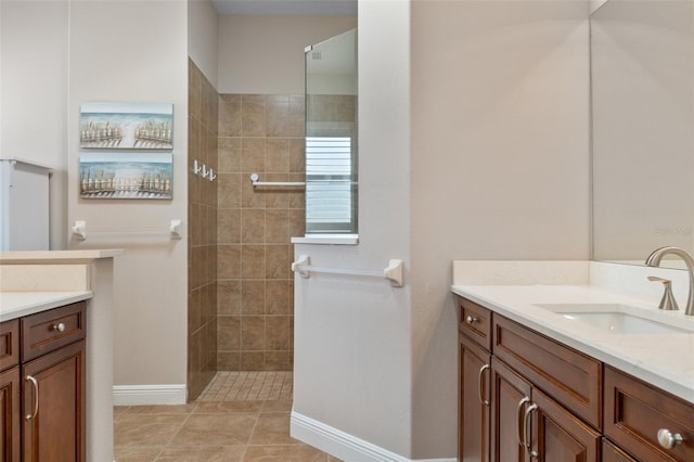 bathroom featuring tiled shower, vanity, and tile patterned floors