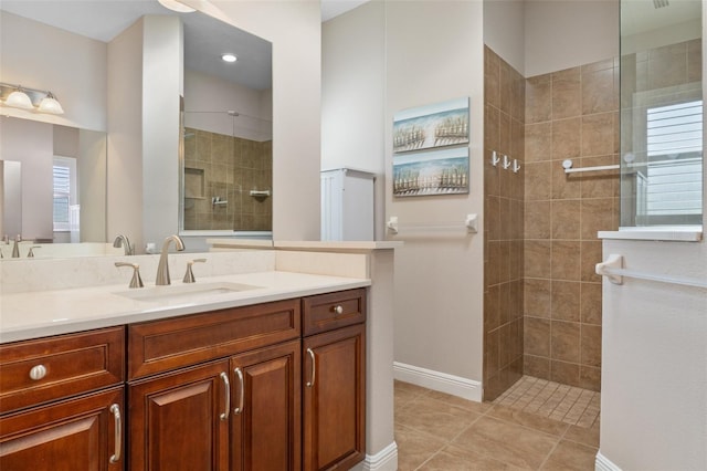 bathroom with tile patterned flooring, vanity, and tiled shower