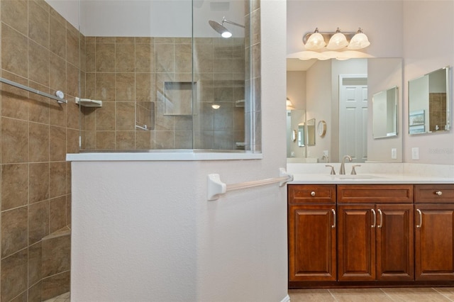 bathroom featuring tile patterned floors, vanity, and tiled shower