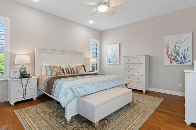 bedroom with ceiling fan, dark hardwood / wood-style floors, and multiple windows