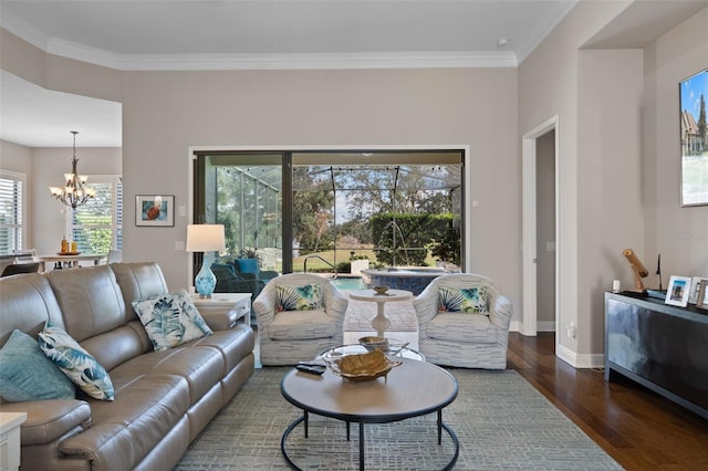 living room featuring dark hardwood / wood-style flooring, ornamental molding, and a chandelier