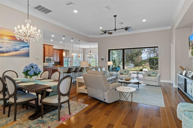 living room with crown molding, a chandelier, and dark hardwood / wood-style floors