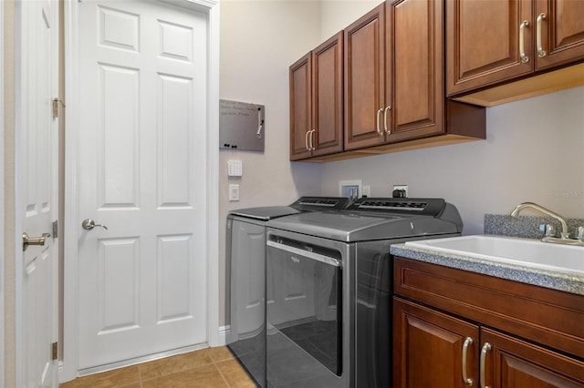 washroom with cabinets, independent washer and dryer, light tile patterned floors, and sink