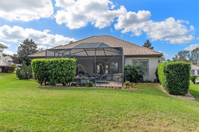 back of house featuring glass enclosure, a patio area, and a yard