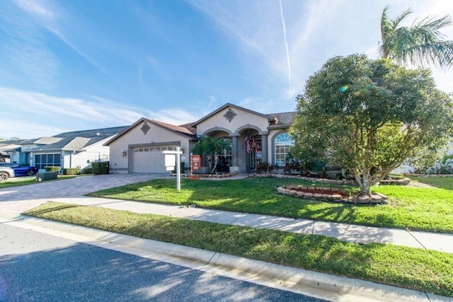 ranch-style house featuring a garage and a front lawn