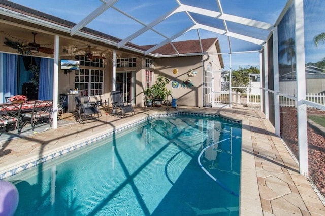 view of pool with ceiling fan, a lanai, and a patio