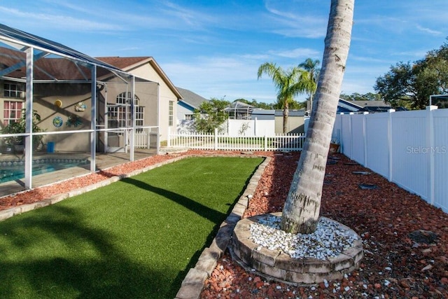 view of yard with a lanai and a fenced in pool