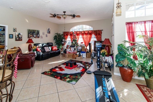 living room featuring a textured ceiling, ceiling fan, and light tile patterned flooring