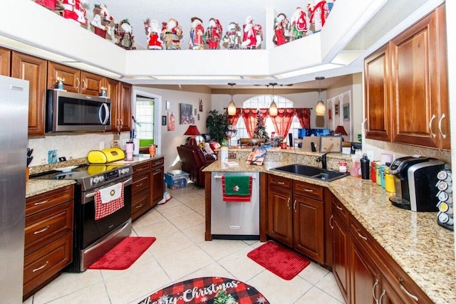 kitchen with kitchen peninsula, stainless steel appliances, sink, decorative light fixtures, and light tile patterned flooring