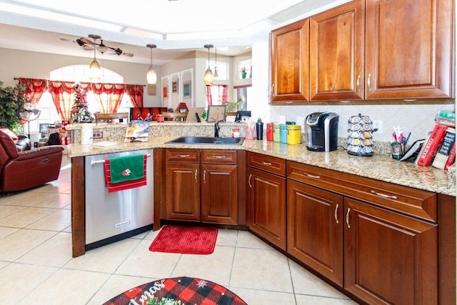 kitchen with sink, hanging light fixtures, stainless steel dishwasher, decorative backsplash, and light tile patterned floors