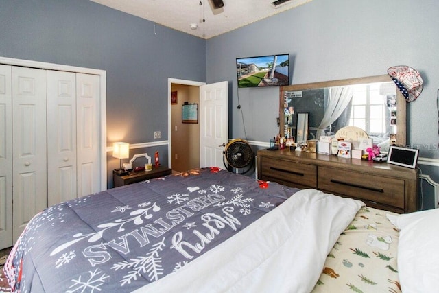 bedroom featuring ceiling fan, a closet, and lofted ceiling