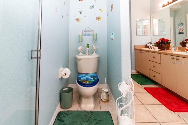 bathroom featuring tile patterned flooring, vanity, toilet, and a shower with door