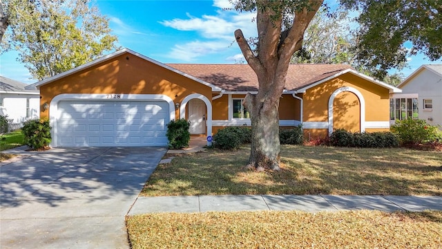 ranch-style house featuring a garage and a front lawn