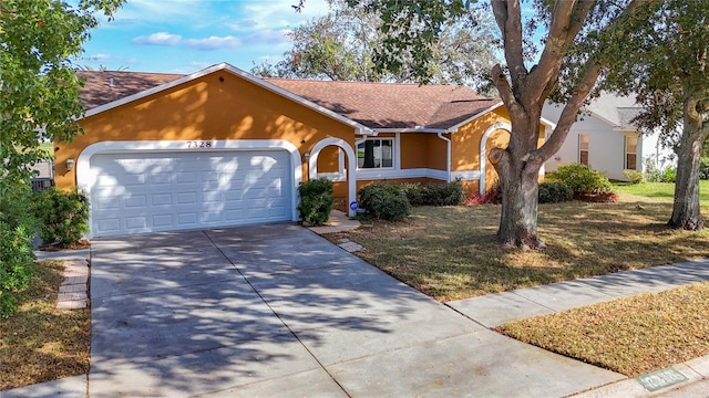 ranch-style house with a garage and a front yard