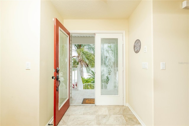 doorway featuring french doors and baseboards