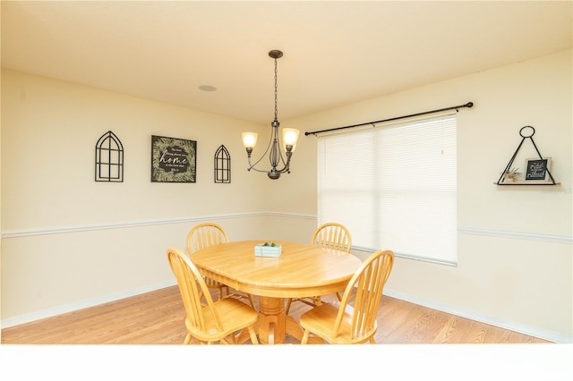 dining area featuring light hardwood / wood-style floors and an inviting chandelier