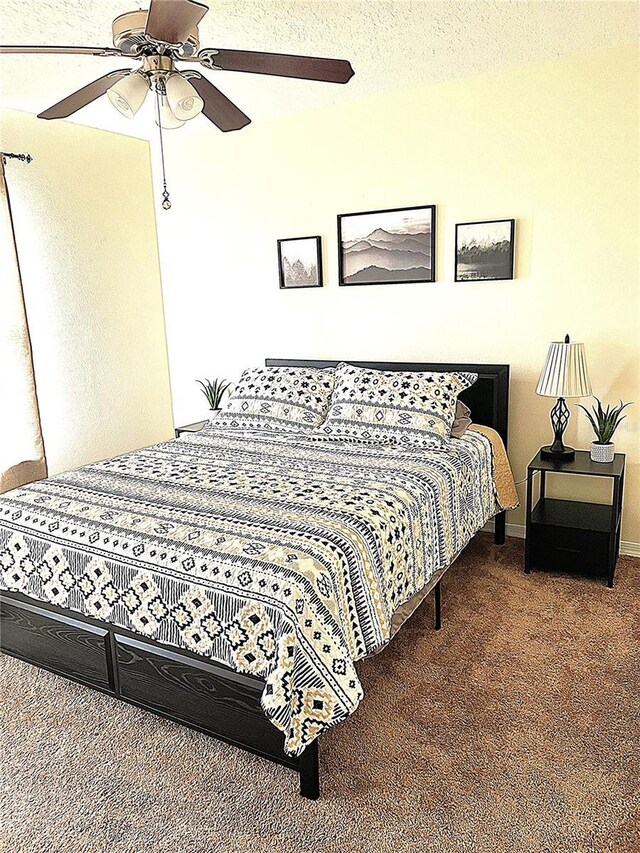 bedroom with a ceiling fan, baseboards, dark colored carpet, and a textured ceiling