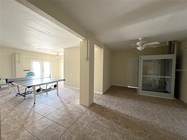 playroom featuring french doors, ceiling fan, a textured ceiling, and baseboards