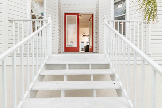 stairs featuring ceiling fan