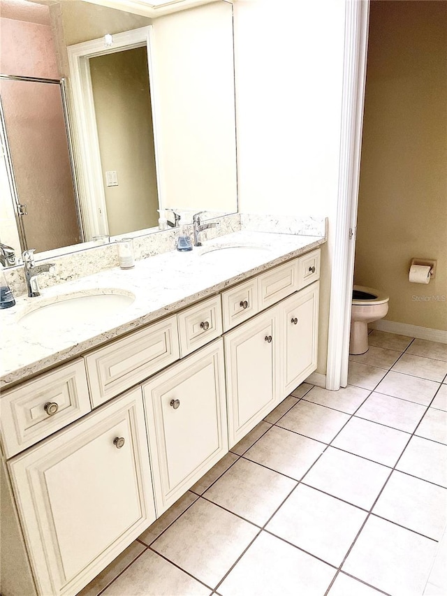 full bathroom featuring double vanity, a sink, toilet, and tile patterned floors