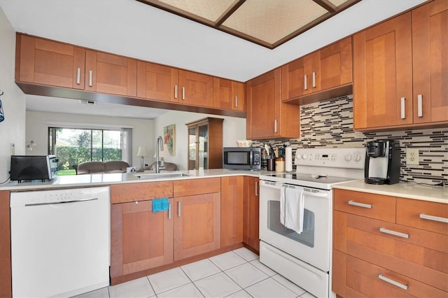 kitchen with white appliances, sink, light tile patterned floors, and tasteful backsplash