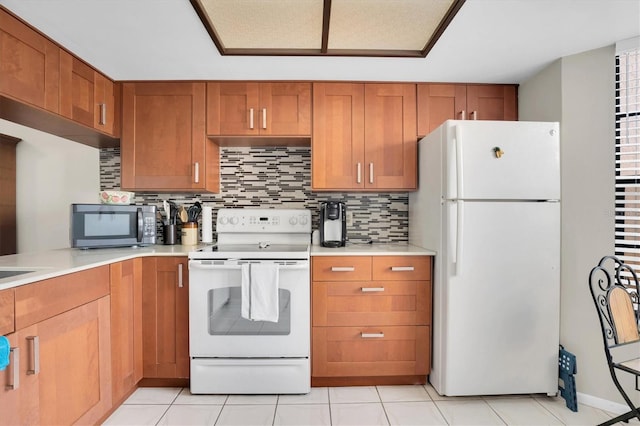 kitchen with light tile patterned flooring, white appliances, and backsplash