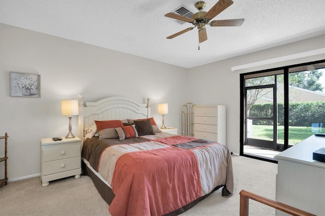 carpeted bedroom featuring access to exterior, ceiling fan, and a textured ceiling