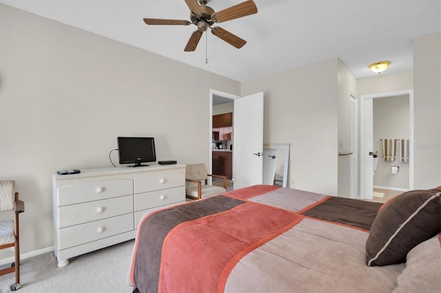 bedroom featuring a textured ceiling, connected bathroom, light colored carpet, and ceiling fan