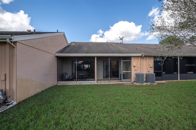 back of house with a sunroom, central AC, and a lawn