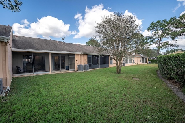 back of property featuring a lawn and cooling unit