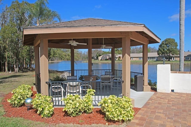 view of patio featuring a gazebo, ceiling fan, and a water view