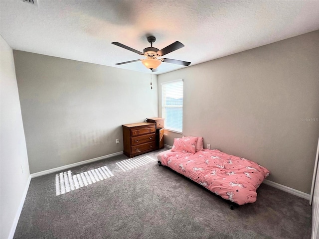 unfurnished bedroom with dark colored carpet, ceiling fan, and a textured ceiling